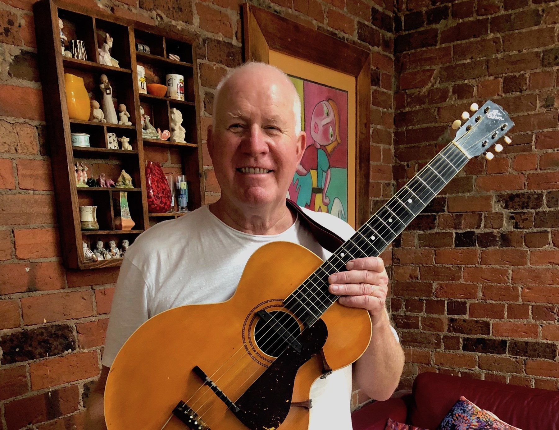 Rob Grenville holding his acoustic guitar